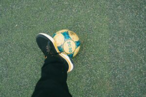 soccer player balances ball on foot outdoors